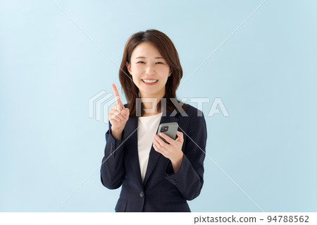 一個穿著西裝的女人拿著智能手機 一個穿著西裝的女人拿著智能手機 94788562