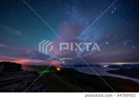 Lake Kussharo seen from Bihoro Pass, a sea of clouds and a starry sky dyed in the city lights 94789502