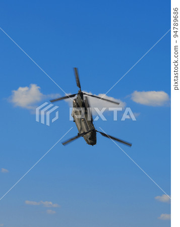 Royal Air Force Chinook HC2 helicopter flying in the blue sky Royal Air Force Chinook HC2 helicopter flying in the blue sky 94789686