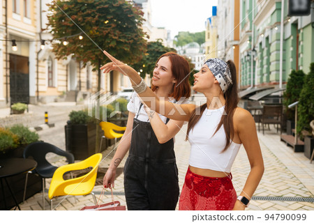 two young women walking outdoor having fun 94790099