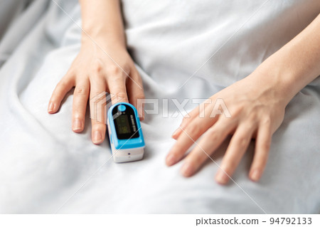 Female hands with a pulse oximeter on the index finger, close-up. A hospitalized patient is in the hospital. Gadgets for maintaining health Female hands with a pulse oximeter on the index finger, close-up. A hospitalized patient is in the hospital. Gadgets for maintaining health 94792133