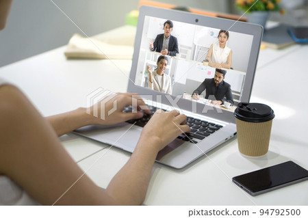 Back view of businesswoman sit at desk in office typing on laptop computer keyboard while  videoconference on-line meeting with business partner. 94792500