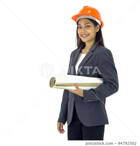 Young asian engineer in gray suit and orange hardhat stand smiling, holding construction drawing of real estate project. Portrait on white background with studio light. Isolated 94792502