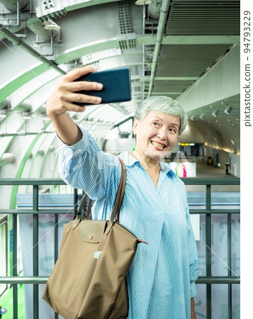 一位 60 歲的成熟亞洲女性寫下智慧型的自我打擊、旅行或觀光探索概念。 一位 60 歲的成熟亞洲女性寫下智慧型的自我打擊、旅行或觀光探索概念。 94793229
