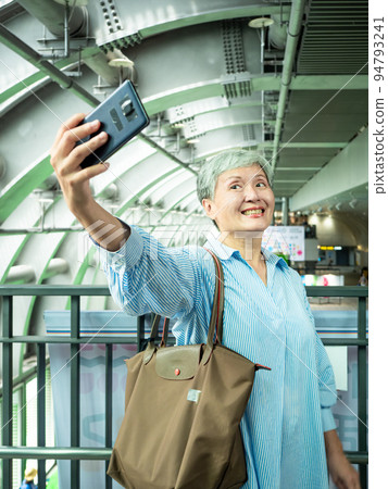 A 60-year-old mature Asian woman writes wisdom-type self-beating, travel or sightseeing exploration concept. A 60-year-old mature Asian woman writes wisdom-type self-beating, travel or sightseeing exploration concept. 94793241