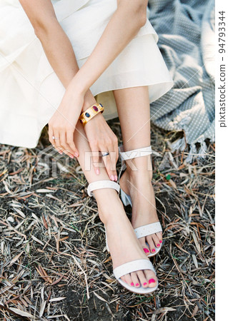 Woman sitting on grass folded her hands in her lap 94793344