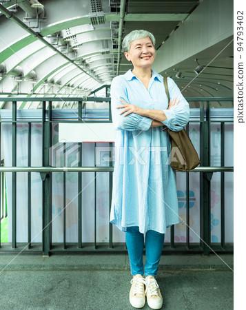 A 60-year-old mature Asian woman in public when she smiles and is full of self-confidence. 94793402