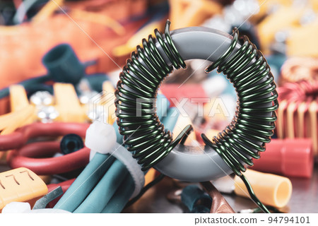 Copper coil and parts of electrical installation with blurred background 94794101
