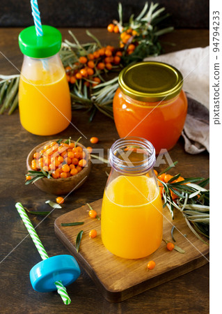 Sweet drink juice with fresh sea buckthorn on a rustic background. Sweet drink juice with fresh sea buckthorn on a rustic background. 94794233