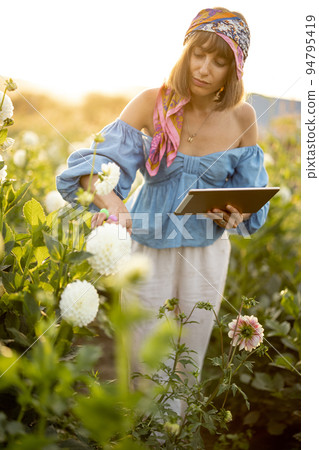 Woman with a digital tablet on flower farm outdoors 94795419