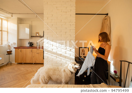 Woman is getting dressed in wardrobe of her apartment 94795499