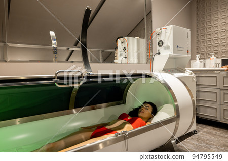 Woman lying in oxygen capsule Woman lying in oxygen capsule 94795549
