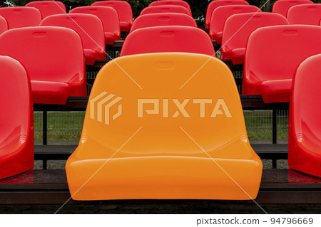 One yellow seat and rows of red ones, as indviduality concept 94796669