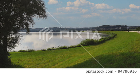 Beautiful lake shore with a big tree, blue sky Beautiful lake shore with a big tree, blue sky 94796910