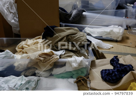 Room messed up with clothes and luggage 94797839