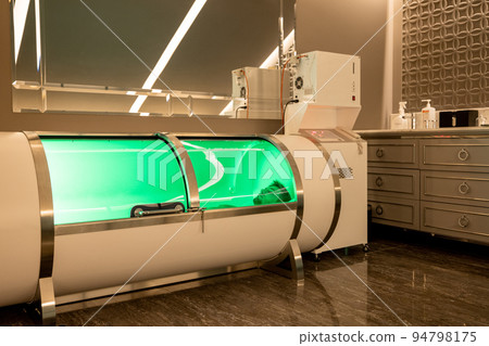 Man lying in oxygen capsule in medical office 94798175