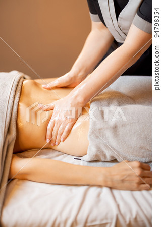 Masseuse performs professional abdominal massage for a woman 94798354