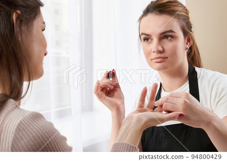 Woman getting a manicure at the nail salon Woman getting a manicure at the nail salon 94800429