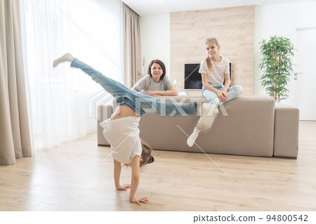 Mother and two daughters having fun in living room at home. Happy family and single mother concept Mother and two daughters having fun in living room at home. Happy family and single mother concept 94800542