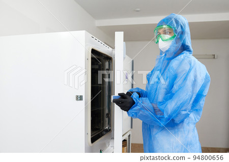 Laboratory worker operating Modern laboratory autoclave sterilizer Laboratory worker operating Modern laboratory autoclave sterilizer 94800656