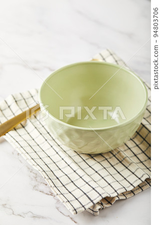 Empty green bowl on napkin on white table 94803706