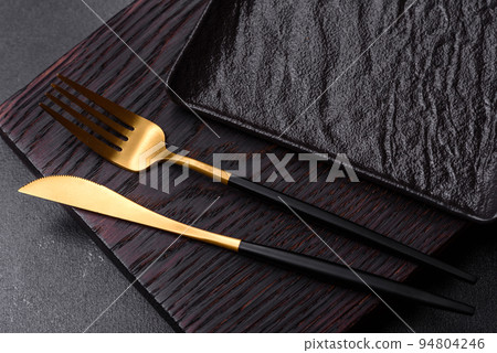 Empty black plate over dark stone background with free space. Top view Empty black plate over dark stone background with free space. Top view 94804246