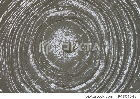 Wet mortar cement paste mixed in bucket, closeup detail from above Wet mortar cement paste mixed in bucket, closeup detail from above 94804545
