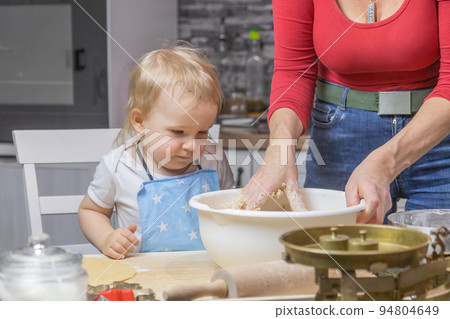 Adorable little child boy is helping mom baking cake Adorable little child boy is helping mom baking cake 94804649