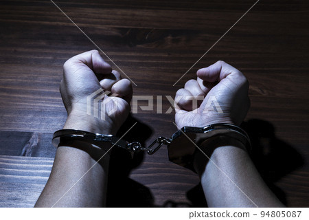 Handcuffed male hand 94805087