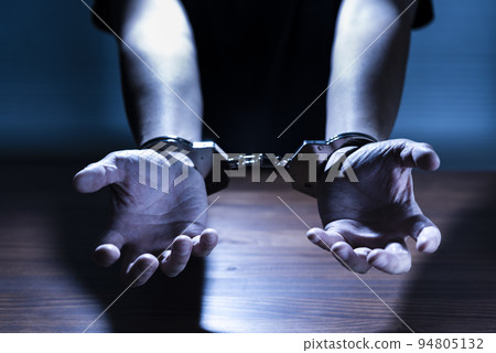 Handcuffed male hand 94805132