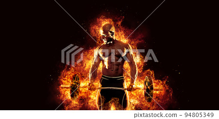 The shirtless abdominal male holds dumbbell. Studio shot in contrasty light 94805349