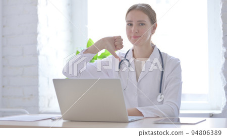 Lady Doctor Showing Thumbs Down While sitting in Clinic 94806389