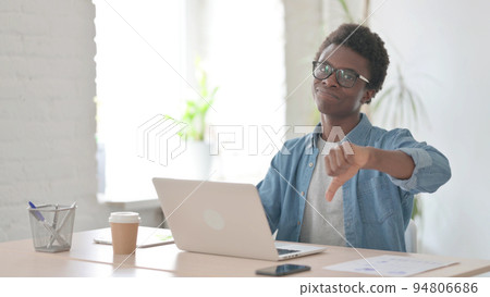 Thumbs Down by Young African Man Using Laptop in Office 94806686