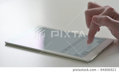 Close up of Hand Typing on Digital Tablet 94806921