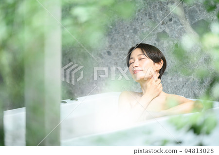 A woman relaxing in a bathtub A woman relaxing in a bathtub 94813028