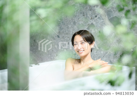 A woman relaxing in a bathtub 94813030