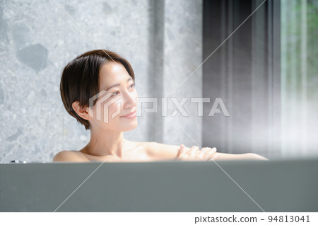 A woman relaxing in a bathtub 94813041