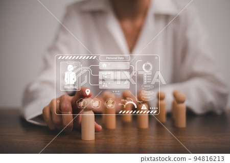 Wooden figurine can be seen in the backdrop as the Human Resource department examines personnel information data to confirm and recruit new team members. 94816213