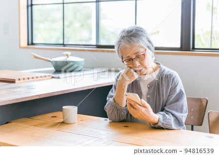 An elderly woman who is in trouble because she does not know how to use a smartphone An elderly woman who is in trouble because she does not know how to use a smartphone 94816539