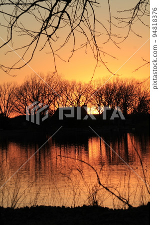 Sunset with water and trees out in the country Sunset with water and trees out in the country 94818376