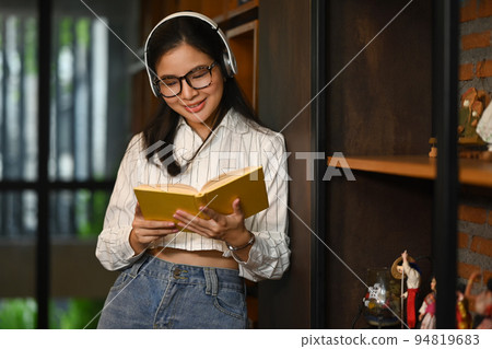 Peaceful young students reading book in modern college library. Education, people and technology concept Peaceful young students reading book in modern college library. Education, people and technology concept 94819683