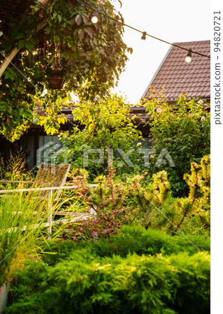A garland with light bulbsin the country house's garden. A garland with light bulbsin the country house's garden. 94820721