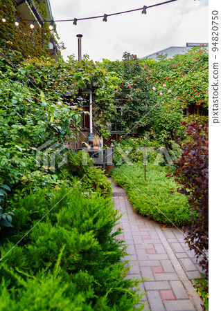 A path in the country house's garden. landscape design of the yard. A path in the country house's garden. landscape design of the yard. 94820750