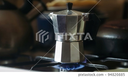 Moka pot brewing on a gas stove. Taditional way of brewing Italian coffee. 94820885