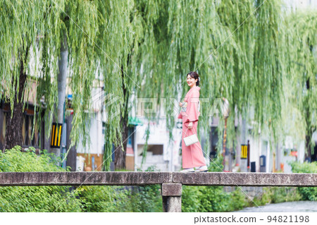 一名身穿和服的女子穿過京都白川河上的一座橋 94821198