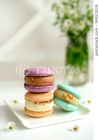 Delicious fresh macaroons with filling on a light wooden background 94821616