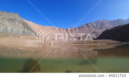 The emerald color of the water of a mountain lake The emerald color of the water of a mountain lake 94821720