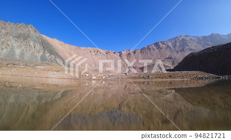 Transparent mountain lake surrounded by high cliff 94821721