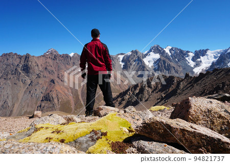 The guy looks at mountains and snow-capped peaks 94821737
