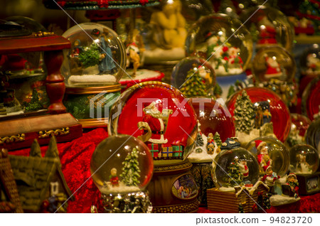 Advent Bazaar Stalls with glass, wooden, ceramic christmas souvenirs in shops. Close up of festive decorations for tree in winter street night market during new year's holiday. Illuminated fair kiosk Advent Bazaar Stalls with glass, wooden, ceramic christmas souvenirs in shops. Close up of festive decorations for tree in winter street night market during new year's holiday. Illuminated fair kiosk 94823720